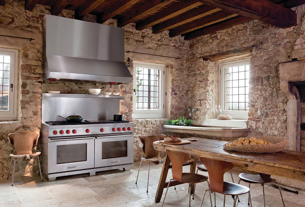Brick wall kitchen with stainless steel range and hood