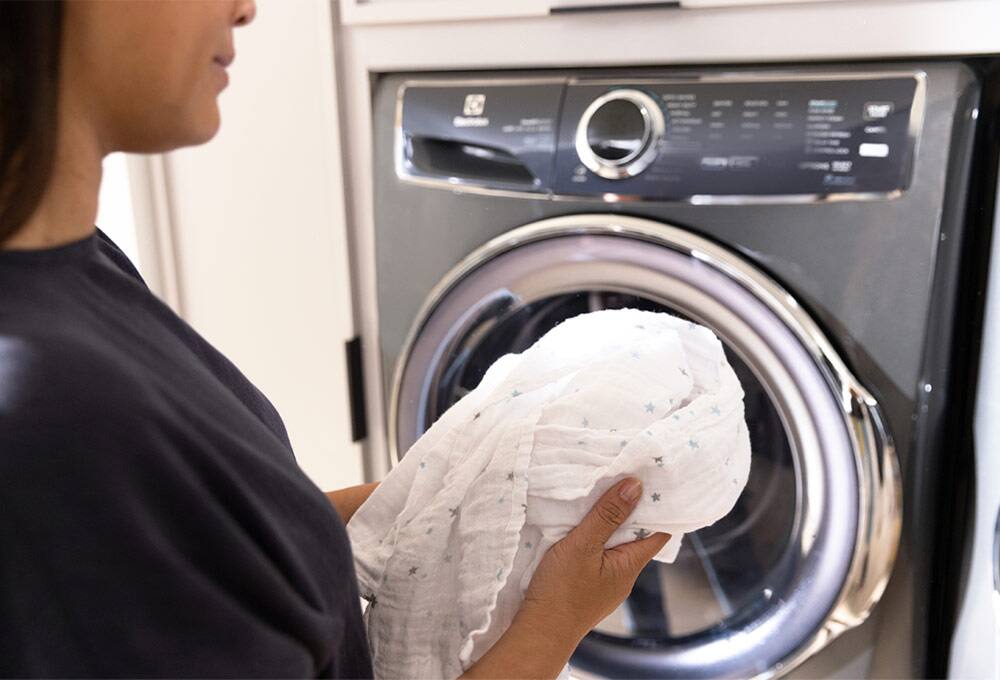 Person putting item into front-loading washer