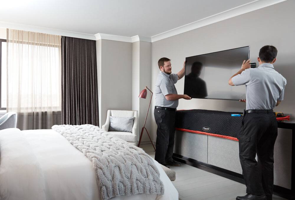 Geek squad agents installing television