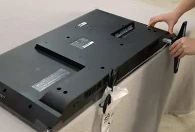 TV stand being put onto a TV