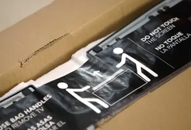 Opened TV box, showing part of the unboxing instructions