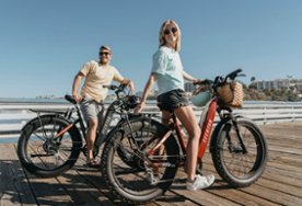 Man and woman straddling electric bicycles
