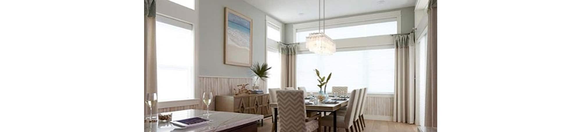 Room with a sectional couch with window shades partially drawn