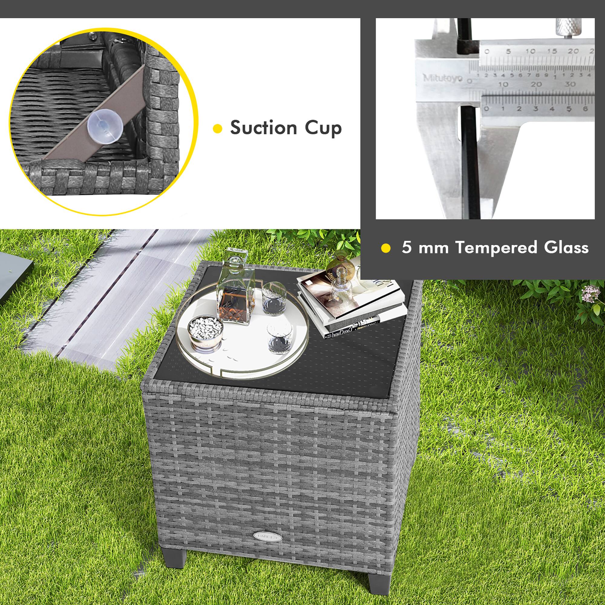 The image shows a table with a suction cup on top of it. The table is made of wicker and has a glass top. The table is placed in a grassy area, and there is a measuring tape nearby. The measuring tape is labeled with the numbers 1, 2, 3, 4, 5, 6, and 10. Additionally, there is a book on the table, and a cup is placed on the table as well.