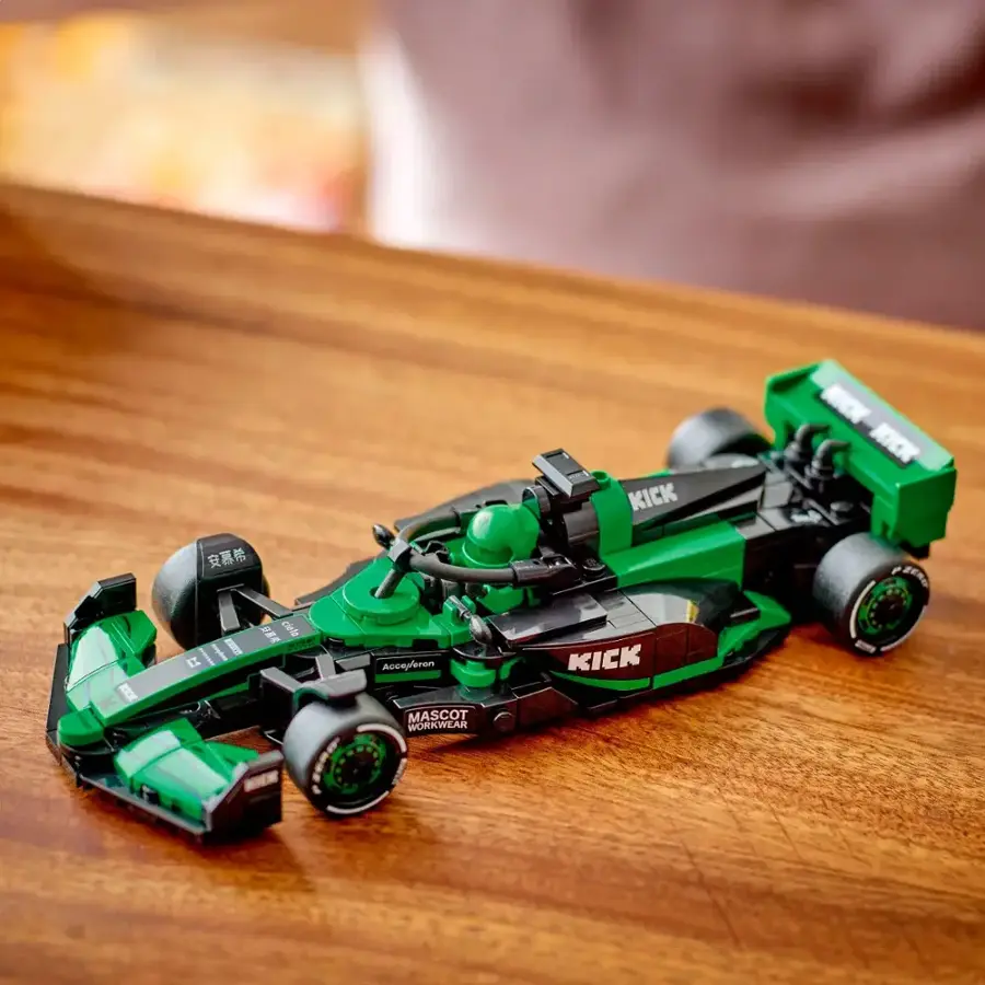 Kick Kick is a brand of workwear that features a mascot on the side of the toy car. The car is green and black in color and is sitting on a wooden surface.