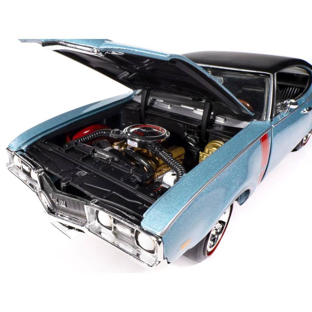 Left. Autoworld - 1968 Oldsmobile 442 W30 Holiday Coupe Teal Frost Metallic with Red Stripes Black Vinyl Top Hemmings Cover 1/18 - Blue.