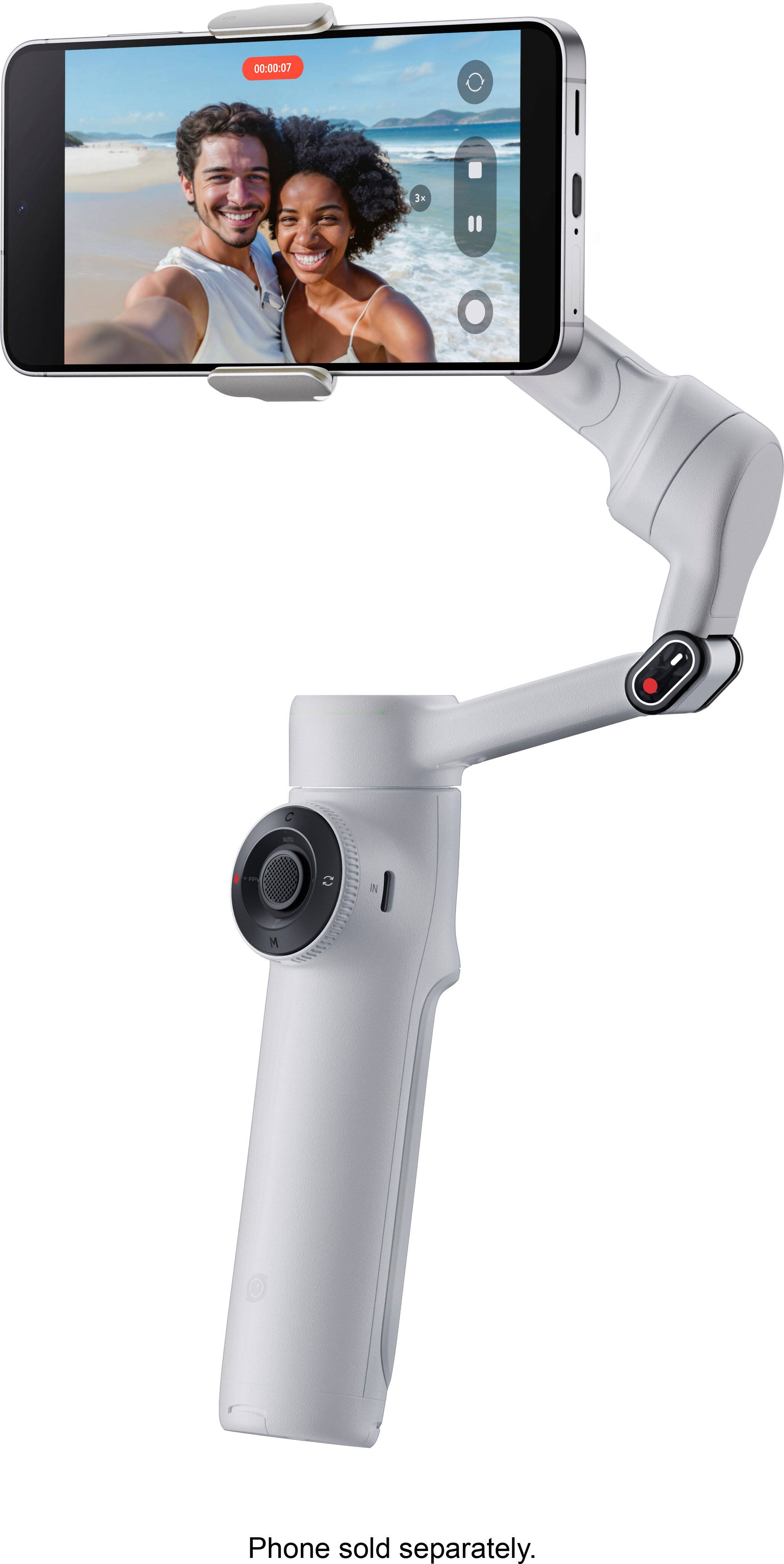 The image features a cell phone attached to a grip, which is designed to hold the phone securely. The grip is connected to a long arm, which allows the user to extend the phone and take photos or videos from a distance. The grip is compatible with smartphones, and the phone is sold separately.