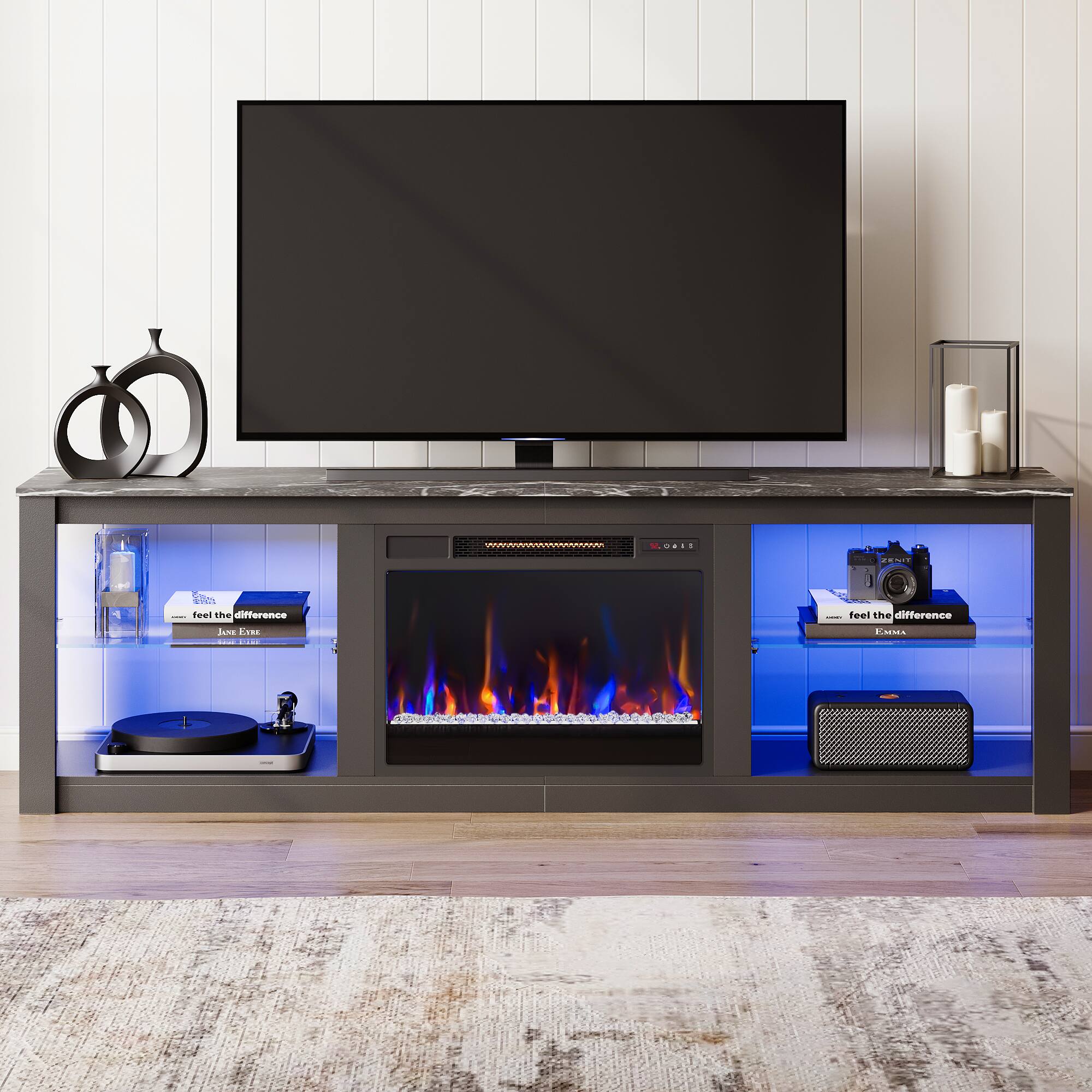 "Feel the difference" is a phrase that is often used to promote the benefits of a product or service. In this context, it could be referring to the fireplace, which is a unique feature of the entertainment center. The entertainment center is designed to hold a flat screen TV and various electronic devices, such as a speaker and a camera. The fireplace adds warmth and ambiance to the space, making it a cozy and inviting environment for relaxation and entertainment.