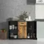 The image shows a kitchen counter with a variety of items on it. There are several bottles, a vase, and a bowl placed on the counter. Additionally, there are multiple cups and bowls arranged on the counter. A potted plant can be seen on the counter as well, adding a touch of greenery to the space. The kitchen counter is situated next to a wall, and a refrigerator is visible in the background.
