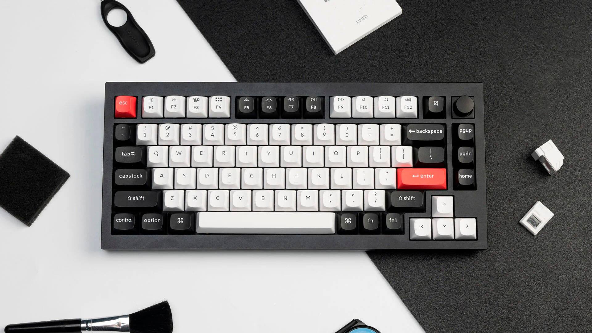 The image shows a black and white keyboard with a red key. The text on the image reads:

"LINED esc F1 F2 go F3 F6 F5 F6 F7 DII F8 DD F9 V F10 d F11 ag F12 I 1 2 # 3 $ 4 % 5 A 6 & 7 . 8 I 9  0 I + = backspace pgup tab W E R T Y U I O P I I I I I \ pgdn caps lock A S D F G H L L : : " . enter home  shift Z x C V  N M < A ? / shift control option 3 2 fn fn1"

The text seems to be describing the keyboard layout and its keys, including the function keys and other special keys.