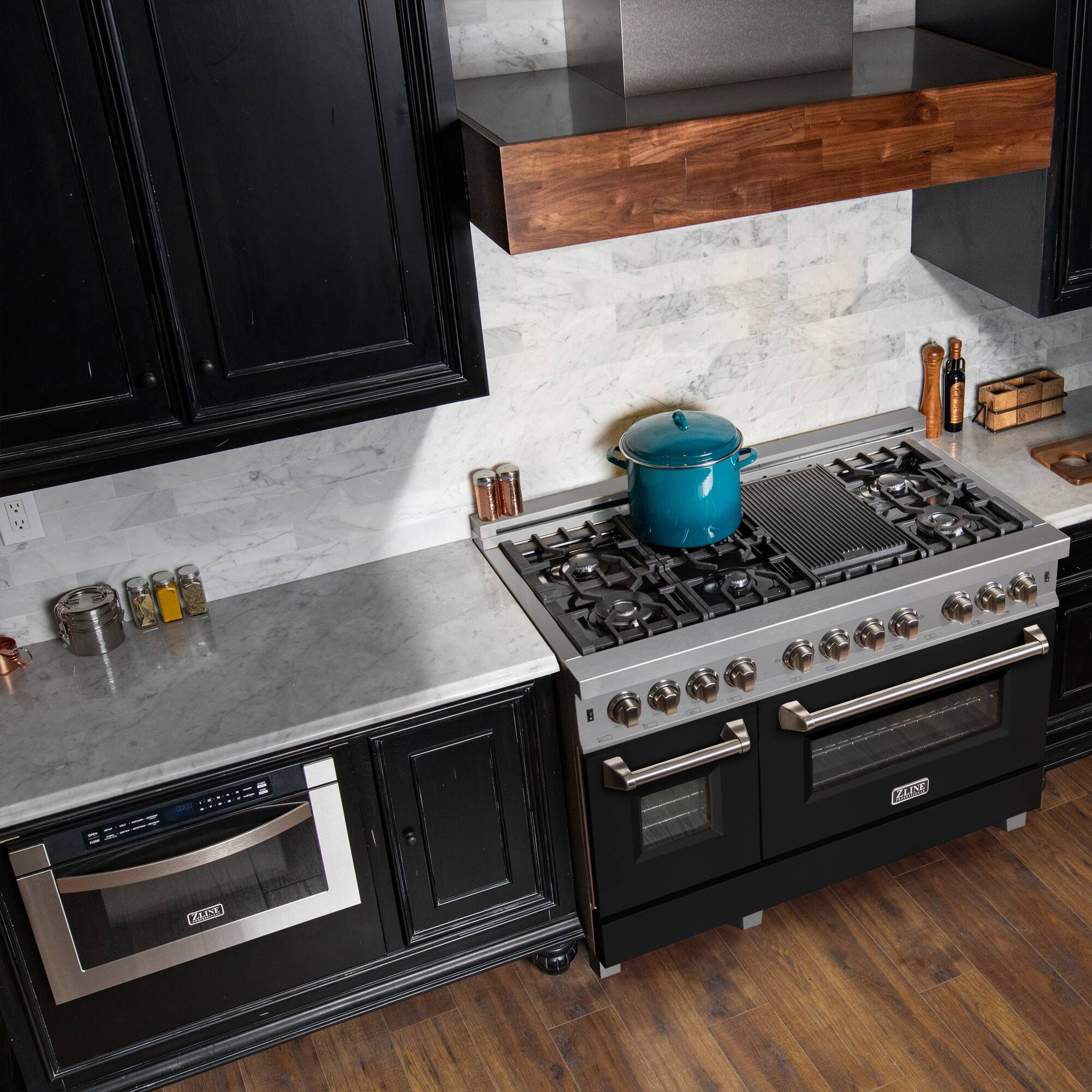 A stove top oven is sitting in a kitchen with a wooden floor. The oven has a blue pot on the stove, and there are several bottles on the counter. The kitchen also features a microwave, and a shelf above the stove.