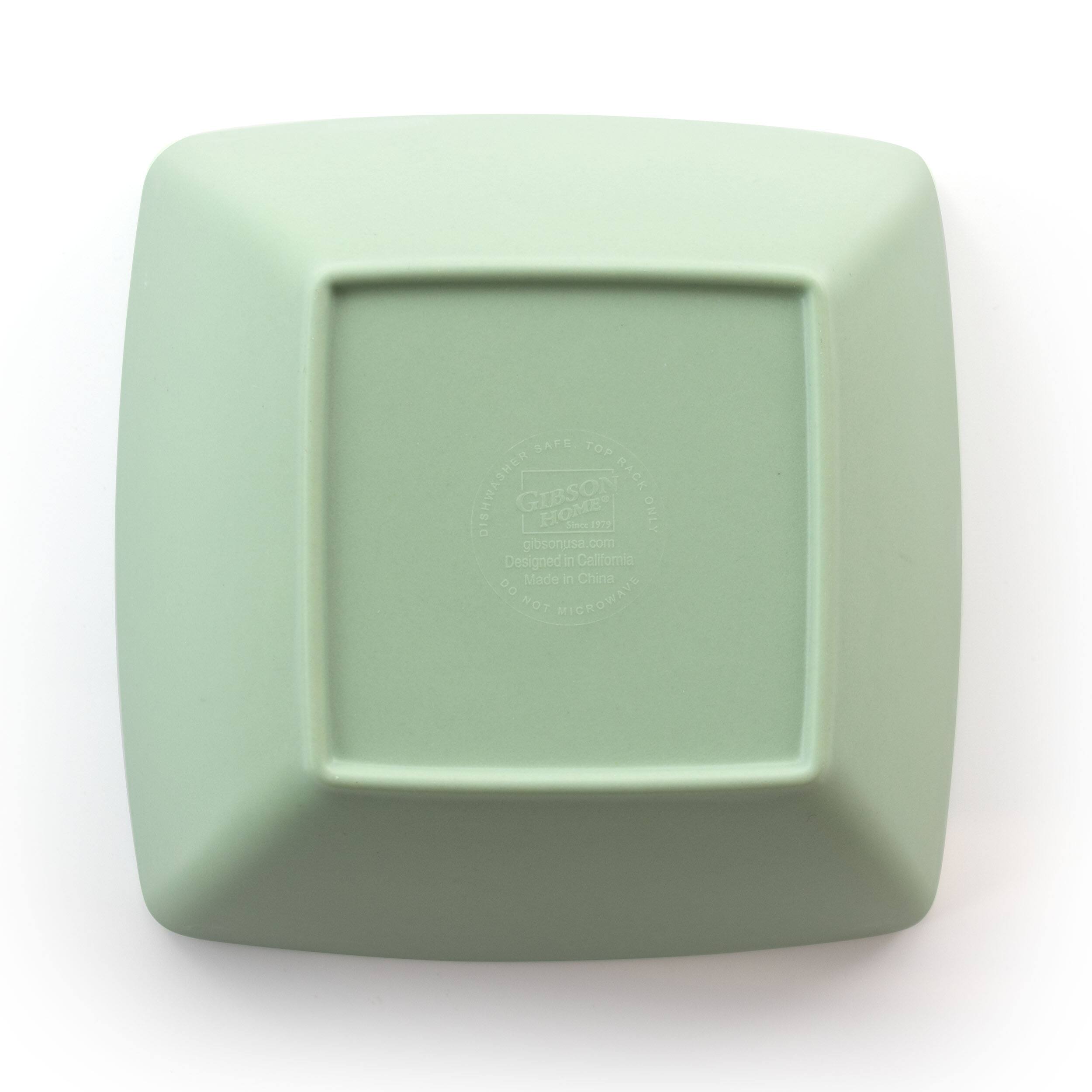 The image features a green square box with a white label on it. The label reads "SALE TOP BSHDAWHEIO RACK GIBSON HOME ONLY Shee Cety 192 gibsonusa.com Designed in Cellfomnia Made in China DO NOT MICROWAVE." The box is likely a microwave-safe container for storing food or other items.