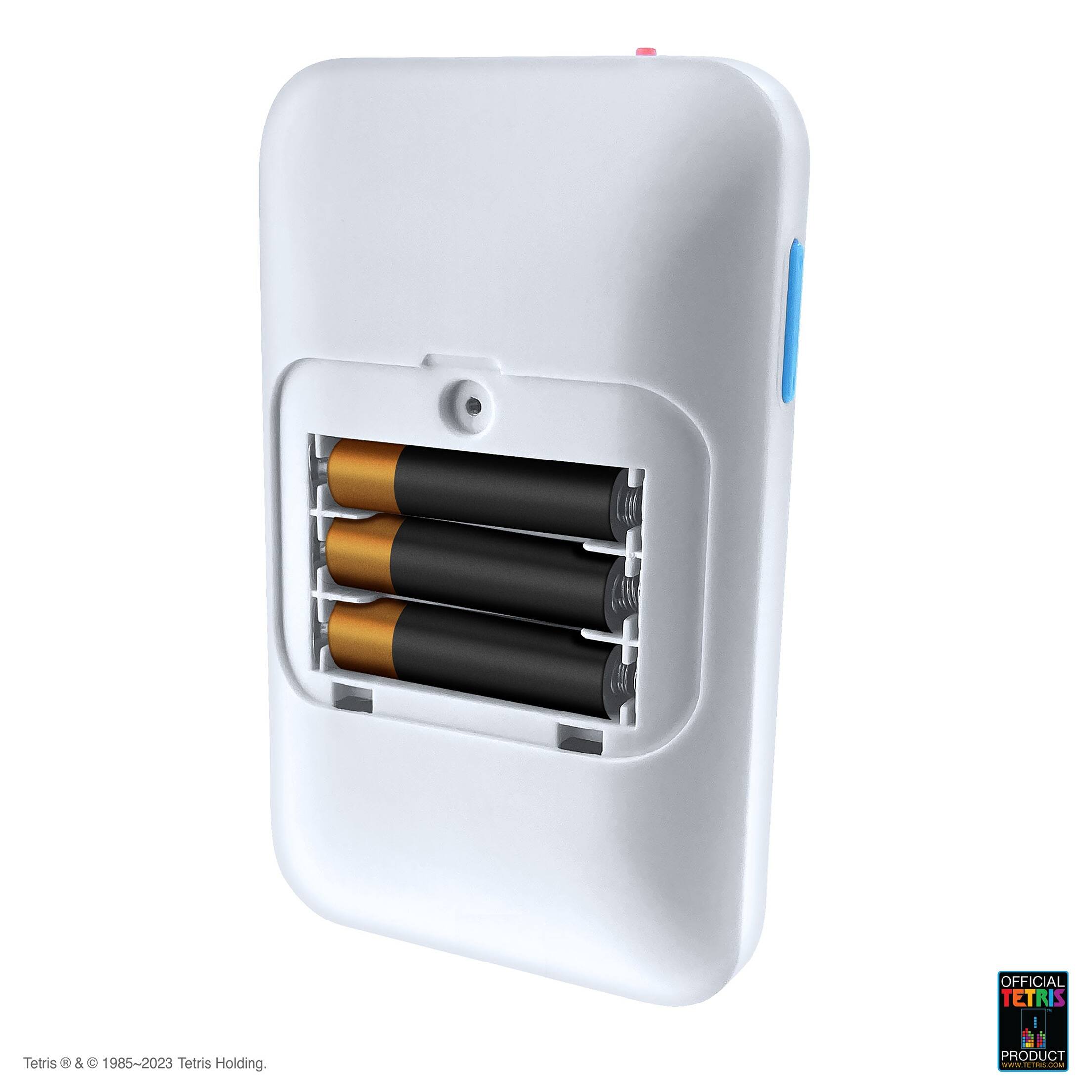 The image features a white box with a blue button on top. The box is designed to hold batteries, specifically AA batteries. The box is labeled "Tetris" and has a blue button on top. The batteries are inserted into the box, and the box is designed to hold multiple batteries. The box is white, and the batteries are visible through the slots. The product is an official Tetris product, and it is designed to hold and organize batteries.
