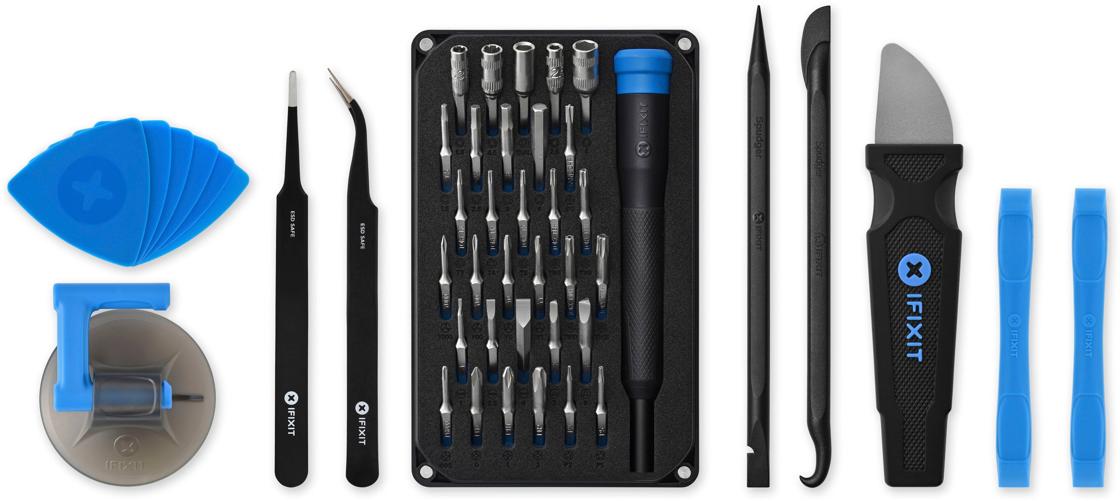 The image features a variety of tools, including a spudger, a pair of scissors, and a drill. The tools are arranged in a neat row, with the spudger being the most prominent. The scissors are positioned next to the spudger, while the drill is located towards the right side of the row. The tools are likely used for different purposes, such as repairing or assembling electronic devices, and they are all part of the IFIXIT toolkit.