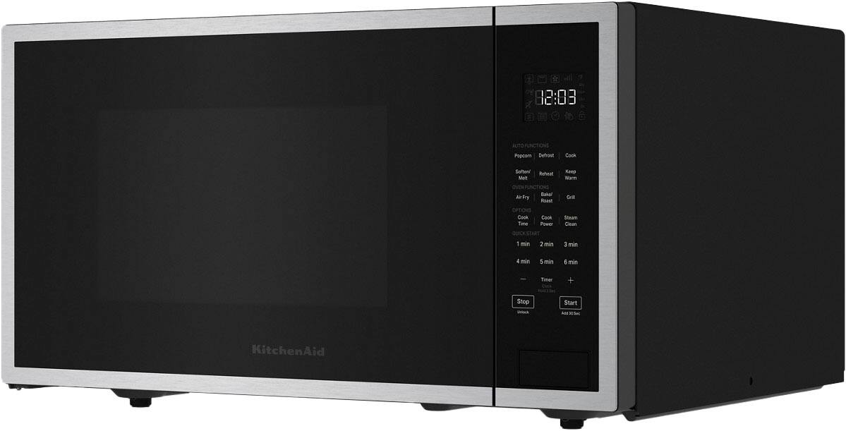 The image shows a black and silver microwave oven with the time 12:33 displayed on the front. The microwave has various functions, including auto functions, papcorn defrost, cock soften, reheat, and oven functions. It also has options for cook time, cook power, steam clean, and quick start. The microwave has a timer clutch and a stop button, and it is made by KitchenAid.