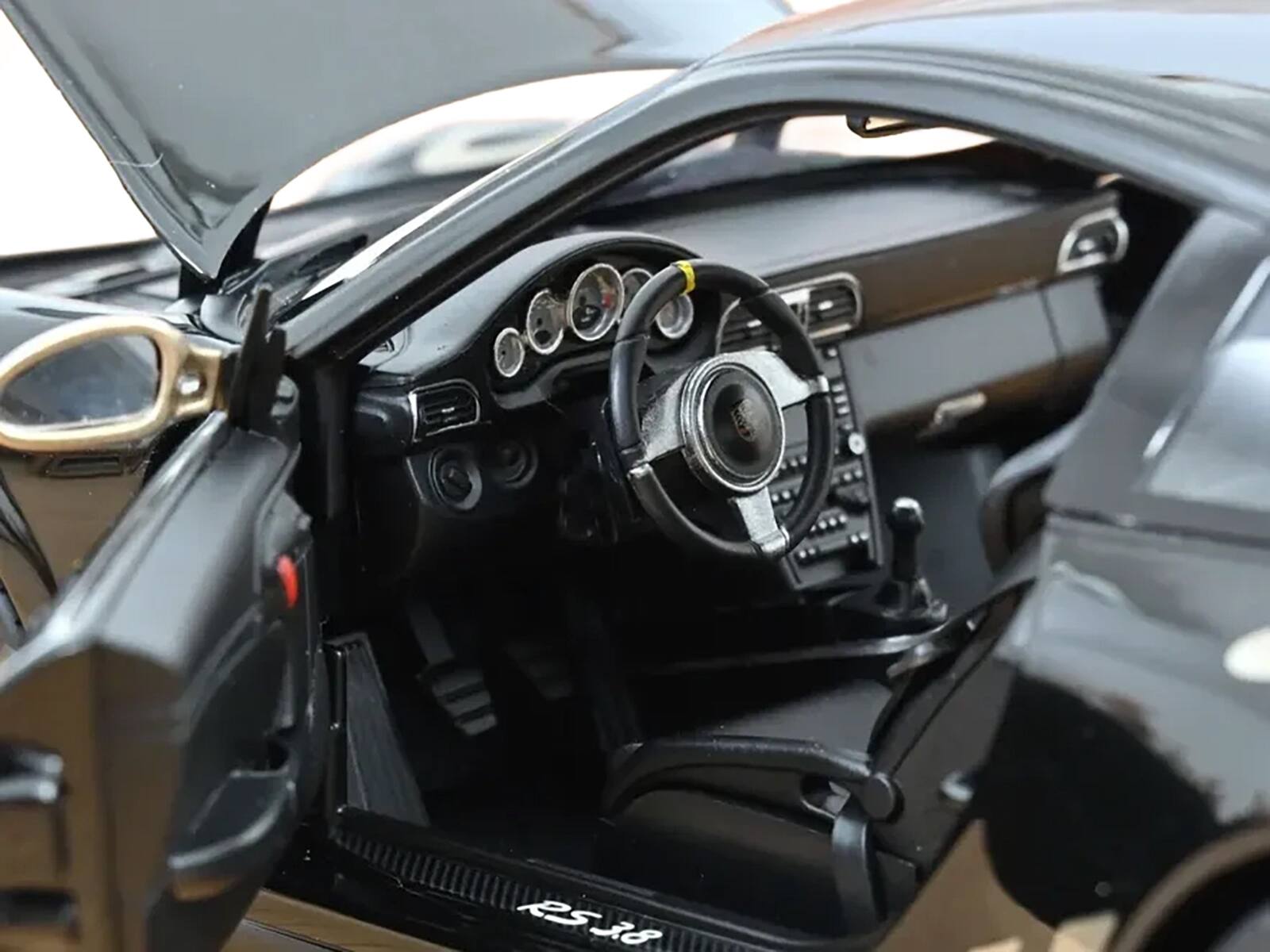 Left. Norev - 2009 Porsche 911 GT3 RS Black with Gold Accents and Wheels 1/18 Diecast Model Car by Norev - Black and Gold.