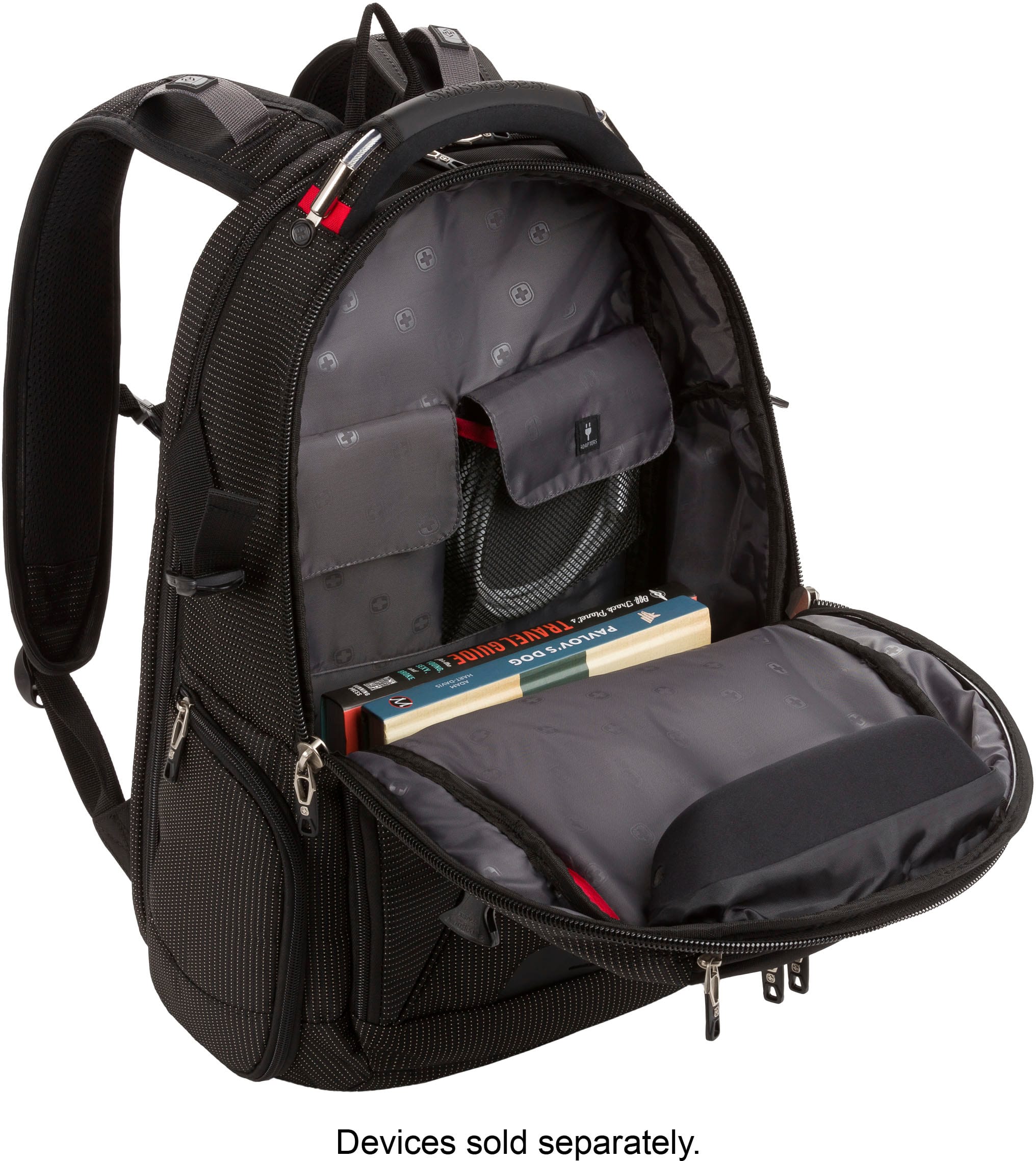 The image shows a backpack with a book and a laptop inside. The backpack is open, revealing the contents. The book is placed on top of the laptop, and the backpack is sitting on a table. The text on the image reads, "Devices sold separately."