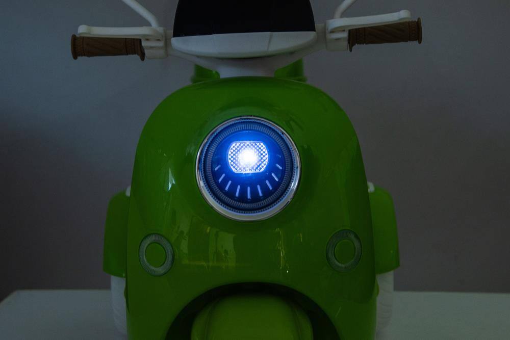 Angle. BreeBe - 12V Kids Electric Motorcycle, 3-Wheel Ride On Scooter w/ USB, Bluetooth, Lights, Storage, Dual Motor, Ages 3+ - Green.