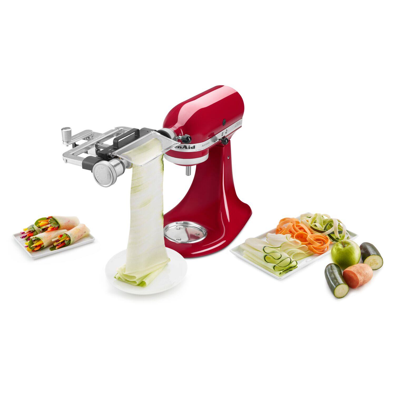 The image features a red food processor, surrounded by various food items. There are two apples, one on the left side and another on the right side of the processor. Additionally, there are two carrots, one on the left side and another on the right side of the processor. The food processor is placed in the center of the image, and it appears to be a prominent focus of the scene.