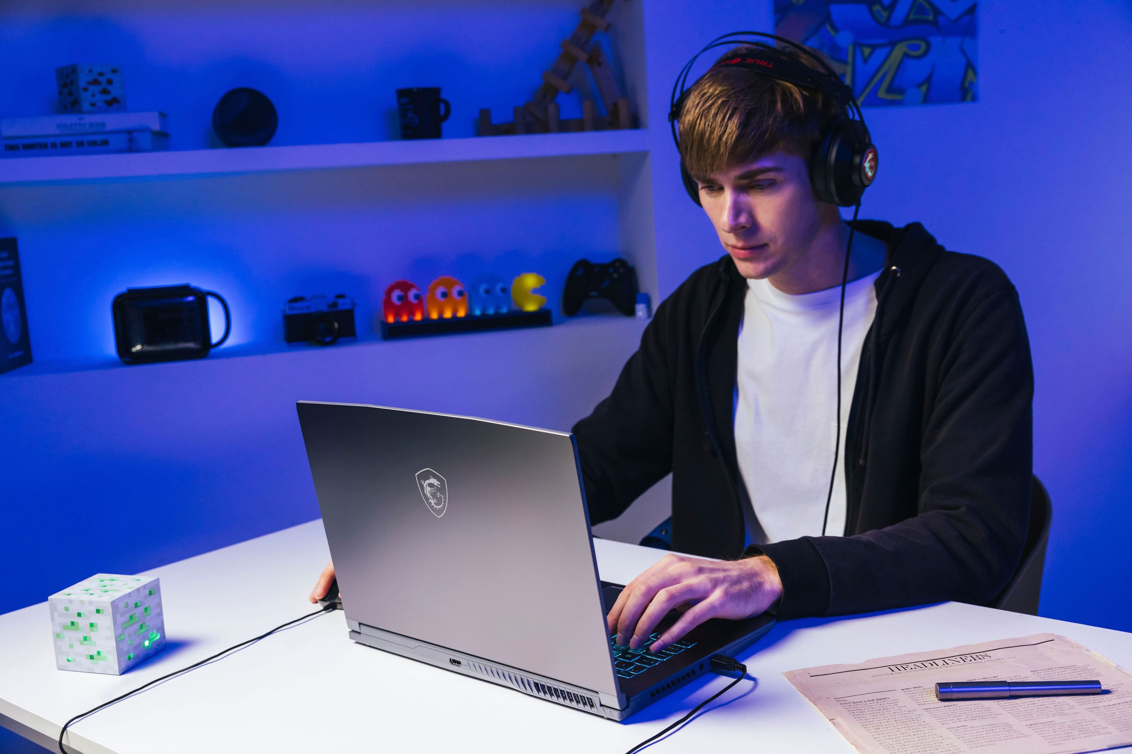 I am a young man wearing headphones and using a laptop.