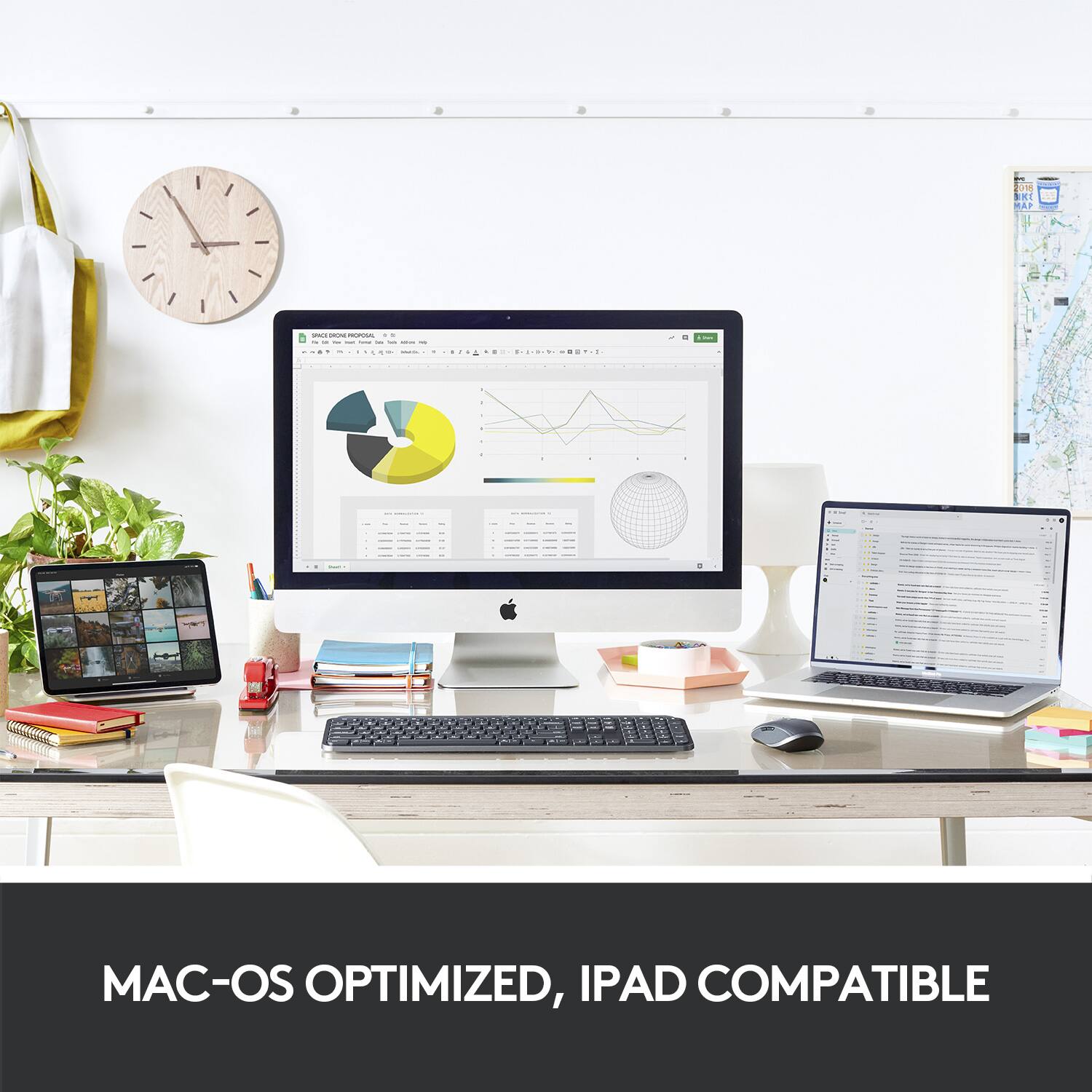 The image shows a computer desk with a desktop computer, a laptop, and a clock. The desktop computer is Mac-OS optimized and iPad compatible. The laptop is also Mac-OS optimized and iPad compatible. The clock is positioned near the computer desk, and there are several books scattered around the desk. The overall scene suggests a workspace that is well-equipped for productivity and efficiency.