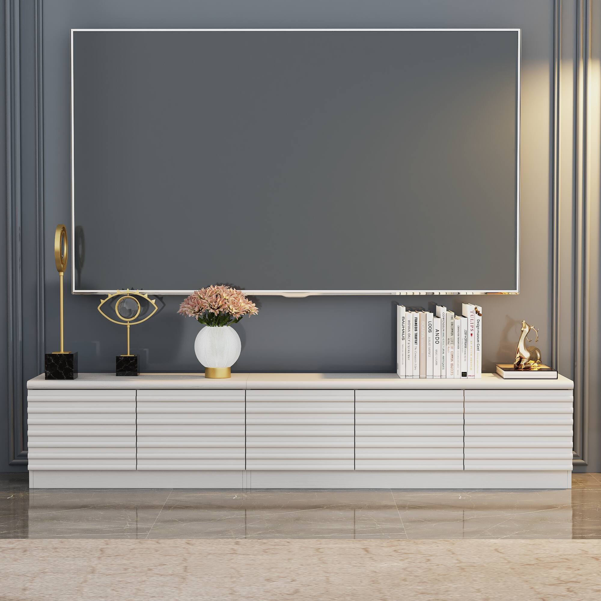 A vase of tulips sits on a table in front of a large screen TV.