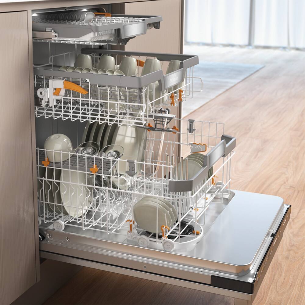 The image shows a dishwasher with a silver rack holding a variety of dishes, including cups, bowls, and plates. The dishwasher is located in a kitchen, and the dishes are being washed and organized on the rack.