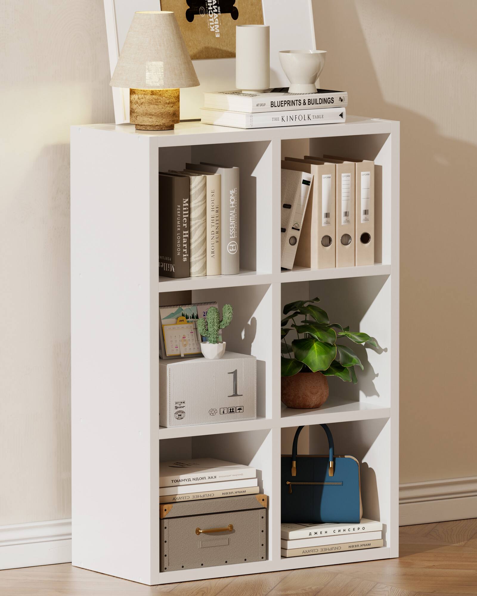 Sure, here is the corrected and grouped text from the image:

---

**Top Shelf:**
- BLUEPRINTS & BUILDINGS
- THE KINFOLK TABLE

**Second Shelf:**
- MILLER Harris
- AROUND THE HOUSE
- THE PERFUMER MILLER HARRIS

**Third Shelf:**
- (Calendar with "1" visible)

**Fourth Shelf:**
- (Books with Cyrillic text, partially visible)

**Bottom Shelf:**
- (Books with Cyrillic text, partially visible)

---

This should reflect the text as it appears in the image.