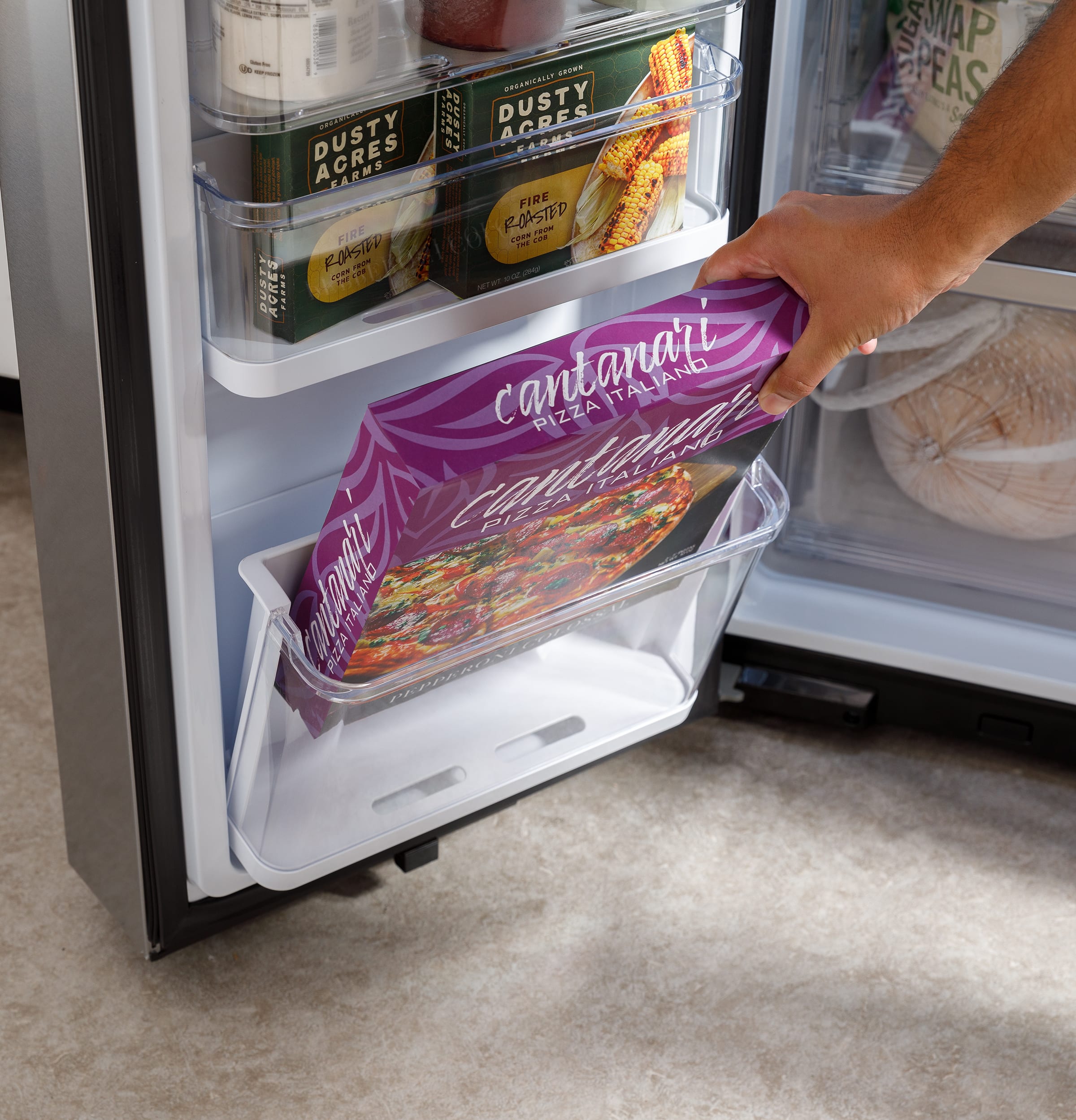 The text on the image is about a refrigerator with a purple bag inside. The bag is filled with pizza, and the refrigerator is stocked with food. The person is holding the purple bag out of the refrigerator, possibly to showcase the contents or to take something out. The text also mentions a recipe book, which might be related to the food inside the refrigerator.