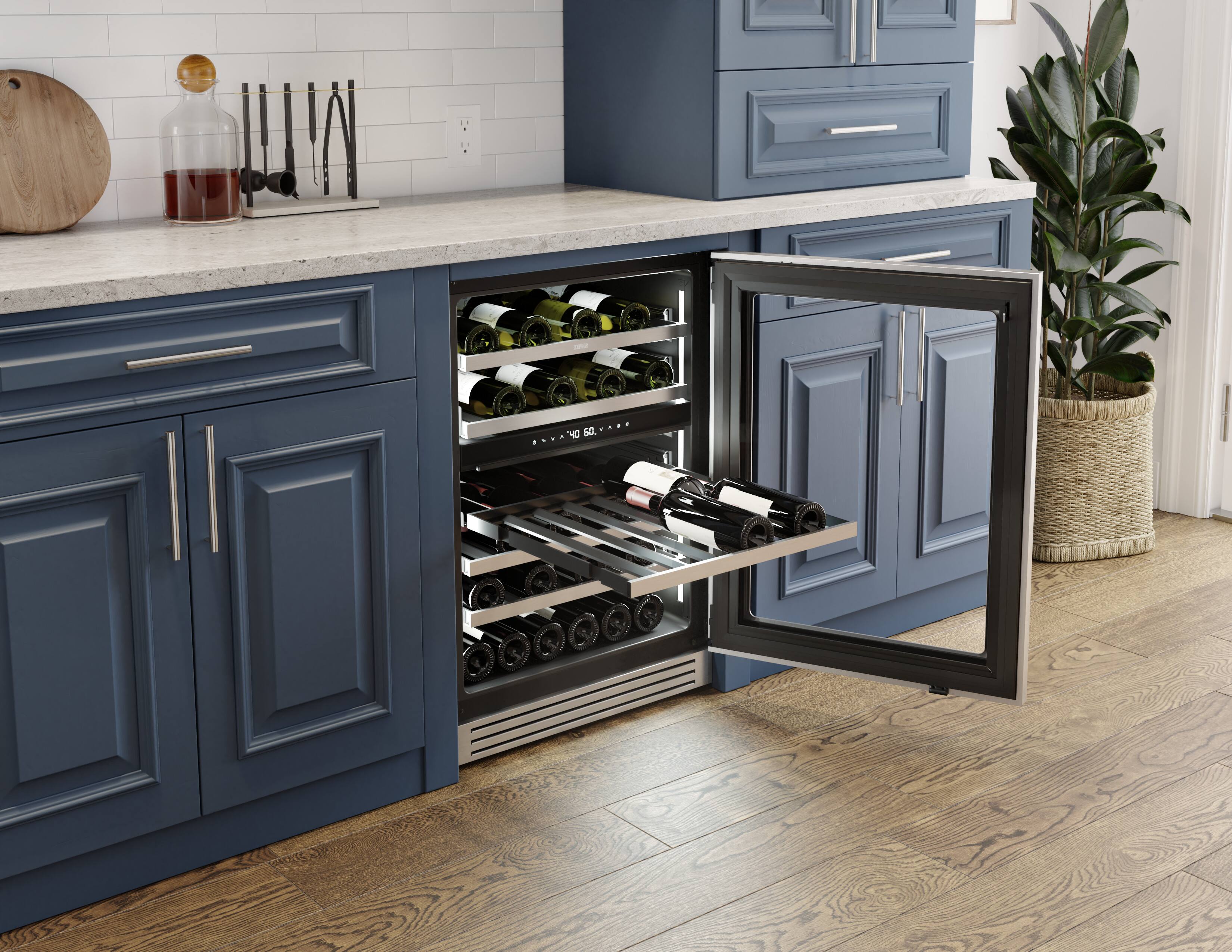 The image shows a kitchen with a blue cabinet that has a wine rack built into it. The wine rack is filled with various bottles of wine, and it is illuminated by a light, making the wine bottles visible. The kitchen also features a sink, a potted plant, and a cutting board.