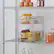 The image shows a shelf with various bottles and cans, including a bottle of orange juice, a bottle of soda, and a bottle of water. There are also some cans of food on the shelf. The shelf is located in a kitchen, and the items are arranged in a way that allows for easy access and organization.