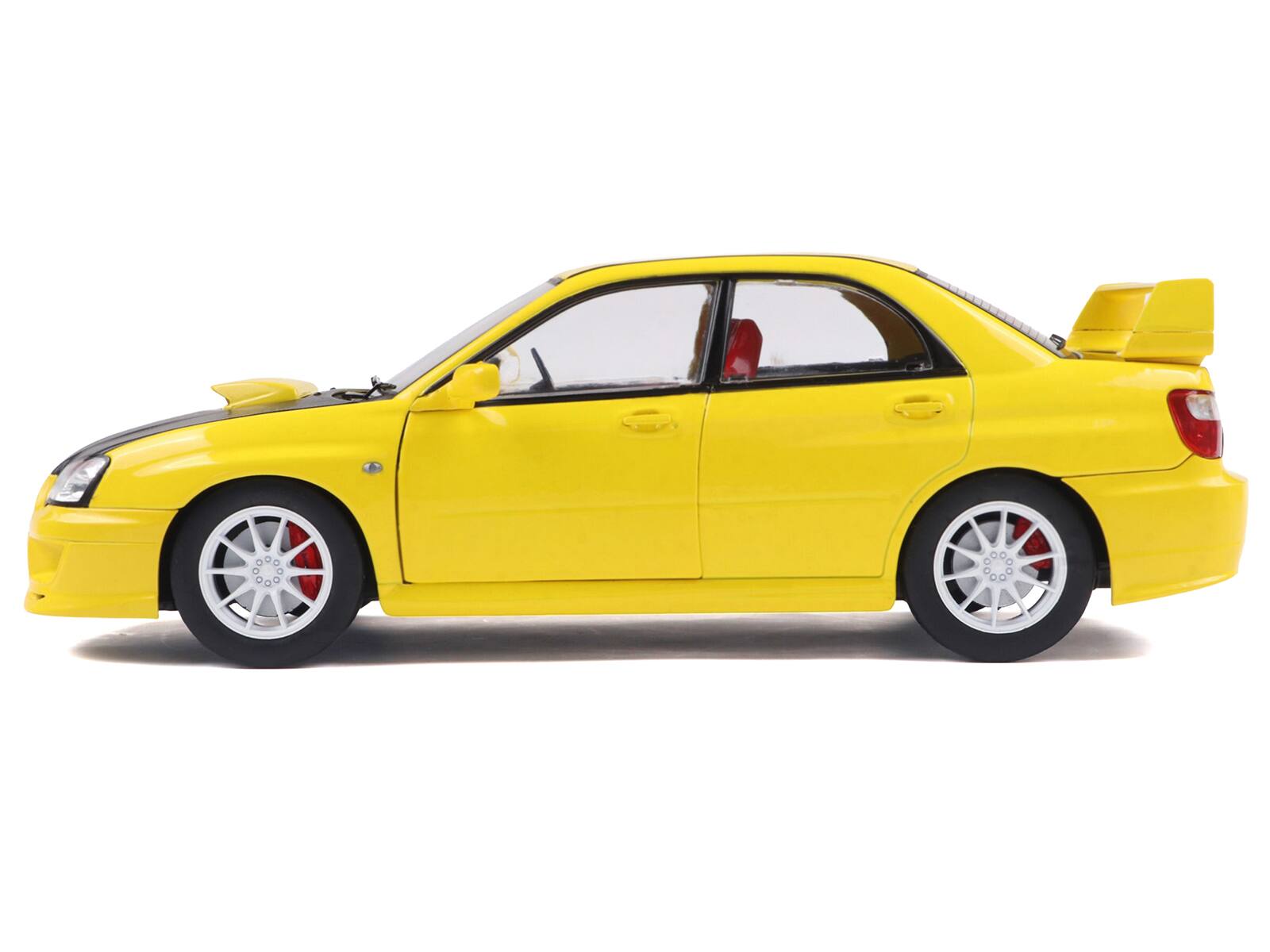 Left. Solido - 2003 Subaru Impreza WRX STI RHD (Right Hand Drive) Yellow with Carbon Hood 1/18 Diecast Model Car by Solido - Yellow.