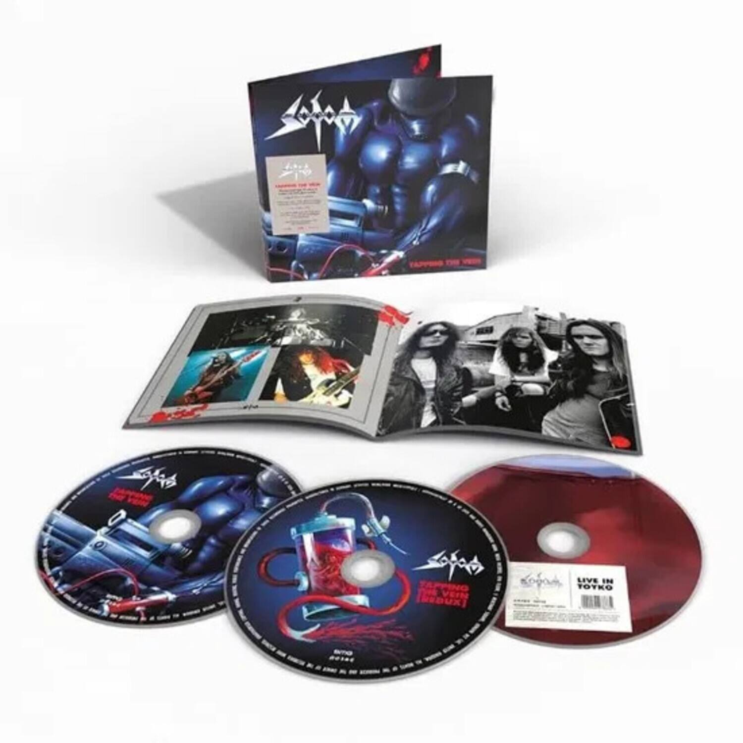 Sure, here is the corrected and grouped text from the image:

---

**Box Cover:**
- TAPPING THE VOID
- TAPPINO PEVEI REDUXI
- LIVE IN TOKYO

**CD 1:**
- TAPPINO PEVEI REDUXI
- TAPPING THE VOID
- LIVE IN TOKYO

**CD 2:**
- LIVE IN TOKYO

**Booklet:**
- (Various images and text related to the band and the live performance)

**Red CD:**
- LIVE IN TOKYO

---