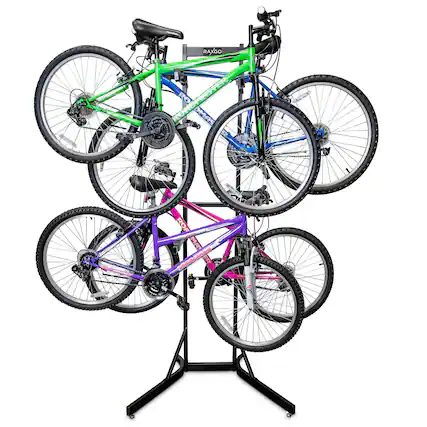 The image features a display of bicycles, including a green one, a blue one, and a purple one. The bikes are arranged on a stand or rack, showcasing their unique colors and designs. The stand is placed on a black surface, which provides a contrasting background for the bikes. The display is likely meant to attract attention and showcase the different options available for potential buyers or enthusiasts.