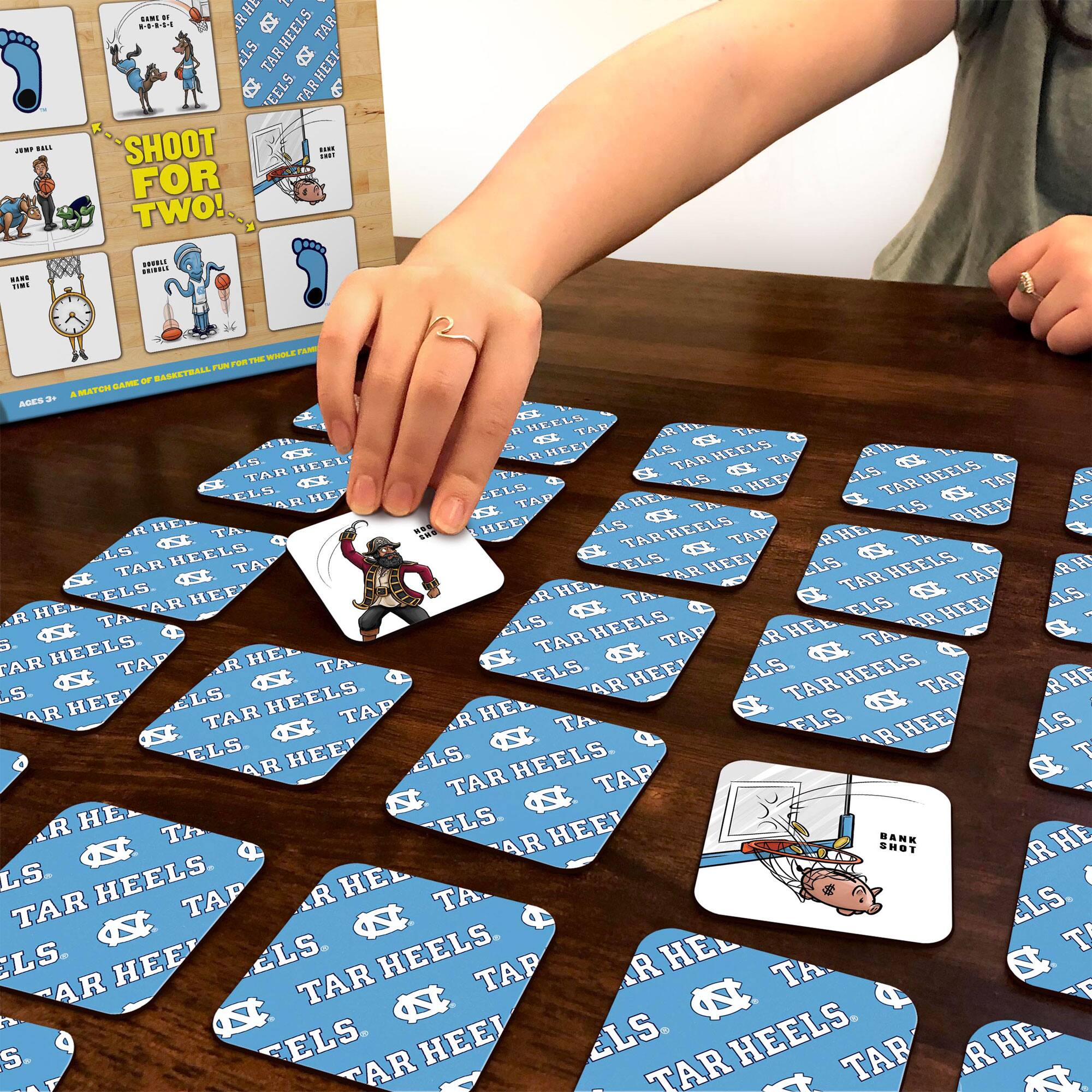 Sure, here is the corrected and grouped text from the image:

---

**Top Left Card:**
- JUMP BALL
- SHOOT FOR TWO!

**Top Right Card:**
- BANK SHOT

**Bottom Left Card:**
- BANK SHOT

**Bottom Right Card:**
- BANK SHOT

**Center Card:**
- TAR HEELS
- TAR HEELS
- TAR HEELS
- TAR HEELS

**Instructions:**
- AGES 8+
- A FAST-PACED GAME OF BASKETBALL. FIND THE TWO OF A KIND TO SCORE!

**Gameplay:**
- TAR HEELS
- TAR HEELS
- TAR HEELS
- TAR HEELS

---