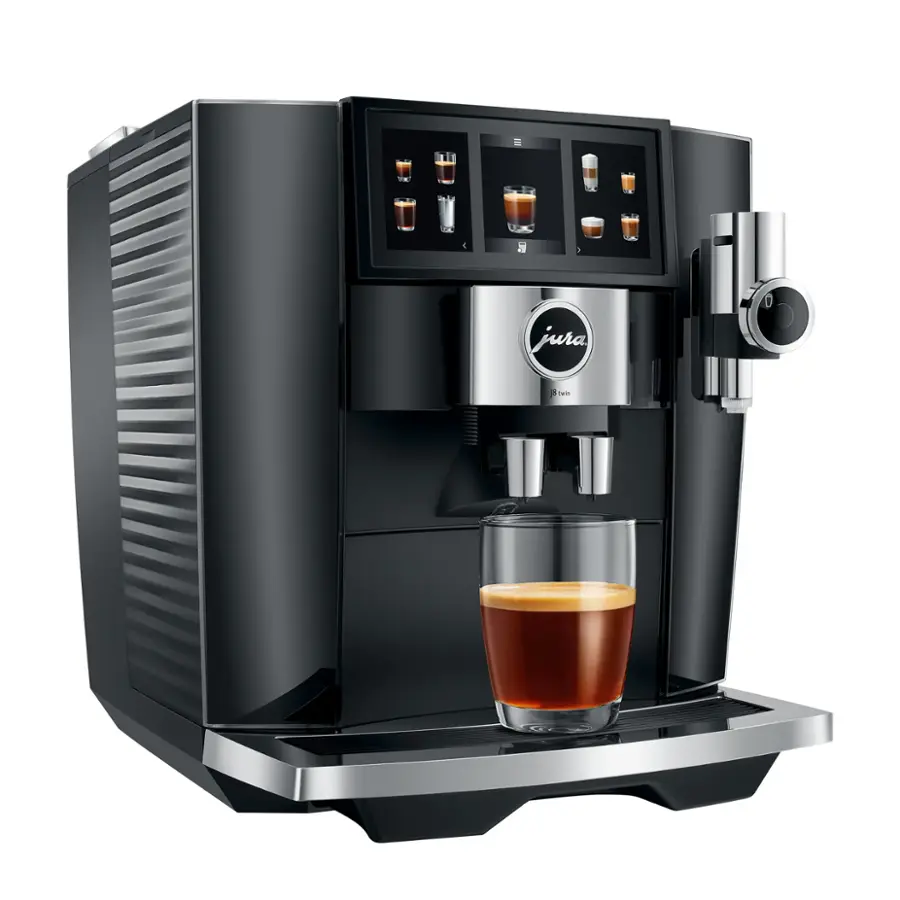 The image shows a Jura coffee machine with a glass of coffee being poured. The machine has a display screen with various coffee options, including espresso, cappuccino, and latte. The coffee is being dispensed into the glass, which is placed on the machine. The Jura coffee machine is known for its high-quality coffee and advanced features, making it a popular choice for coffee enthusiasts.