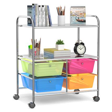 The image features a multi-colored cart with various items on it. There are several books placed on the cart, as well as a clock and a potted plant. The cart is also holding a pair of scissors and a cup. The cart is positioned in front of a bookshelf, which is filled with books. The scene suggests a workspace or a study area where these items are used for different purposes, such as reading, organizing, and working.