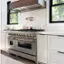 The text "M000 DO00 DOO ZLINE" does not appear in the image. The image shows a kitchen with a stove top oven, a window, and a clock on the wall.