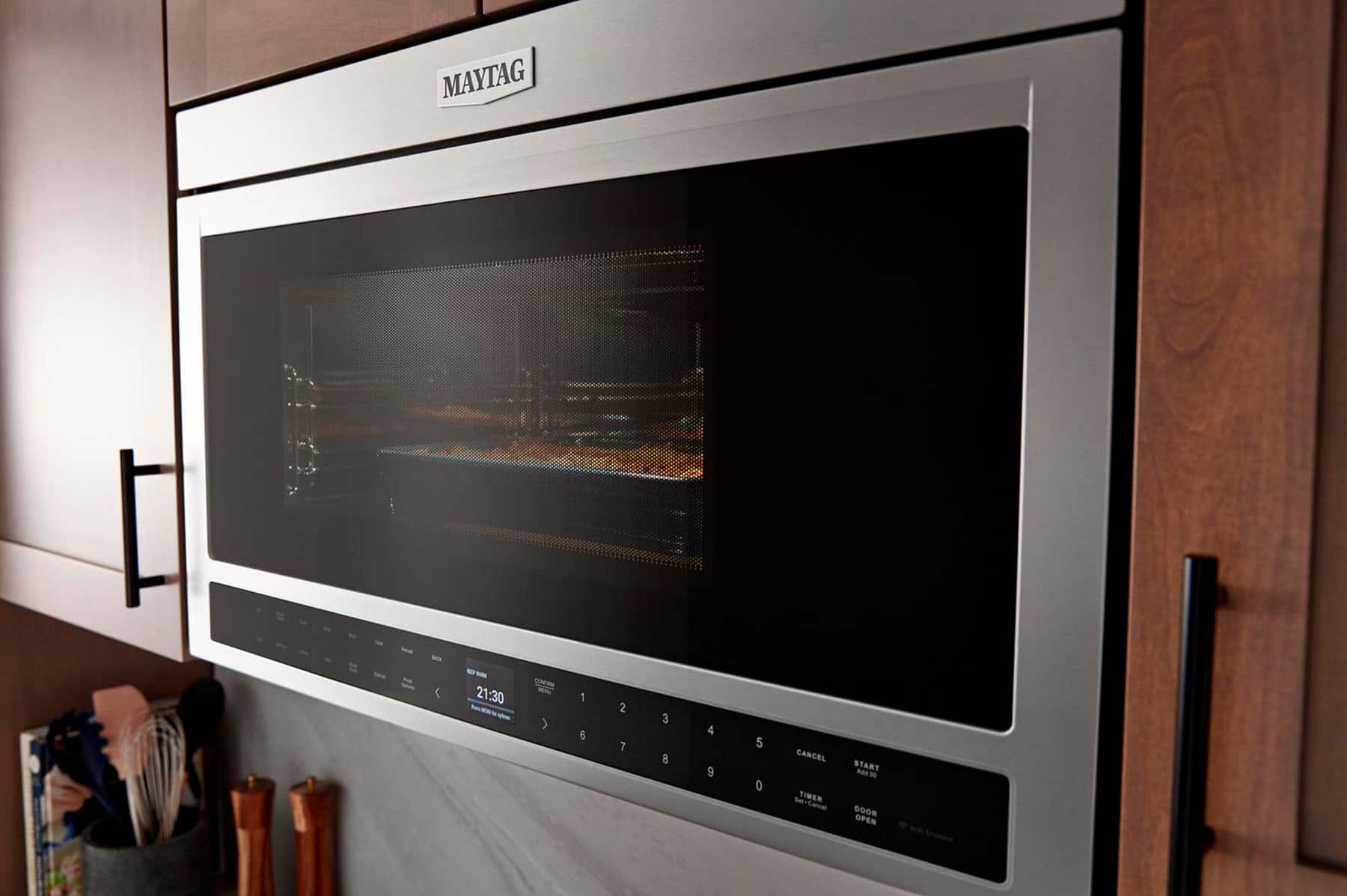 The text on the image reads "MAYTAG 21:30 - > 1 6 2 7 3 8 4 9 5 0 CANCEL TIMER Set-Cancel START MEW DOOR OPEN."