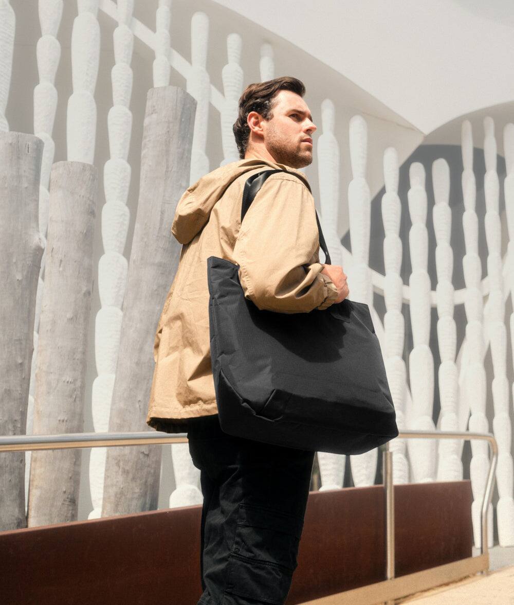 Left. ALPAKA - Elements Tote 20L Laptop Tote Bag with Padded 16" Sleeve,Open Top with Magnetic Closure - Black Axoflux 210D.