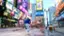 The image features a busy city street with a man in a blue shirt running down the sidewalk. There are several other people walking around, and a few chairs can be seen in the area. The street is lined with various advertisements, including a coffee shop and a movie theater. The scene captures the bustling atmosphere of a metropolitan area.