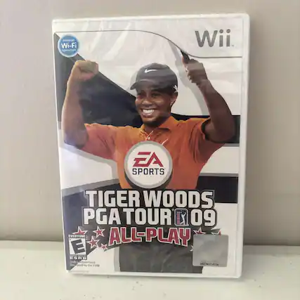 The text on the image is:
"Nintendo Wi-Fi Connection Wii EA SPORTS Tiger Woods PGA TOUR 09 EVERYONE ALL-PLAY E - Rated by the ESRB PG80214734 9021"
Corrected and grouped:
"Nintendo Wi-Fi Connection Wii EA SPORTS Tiger Woods PGA TOUR 09 EVERYONE ALL-PLAY E - Rated by the ESRB PG80214734 9021" - E (Everyone)