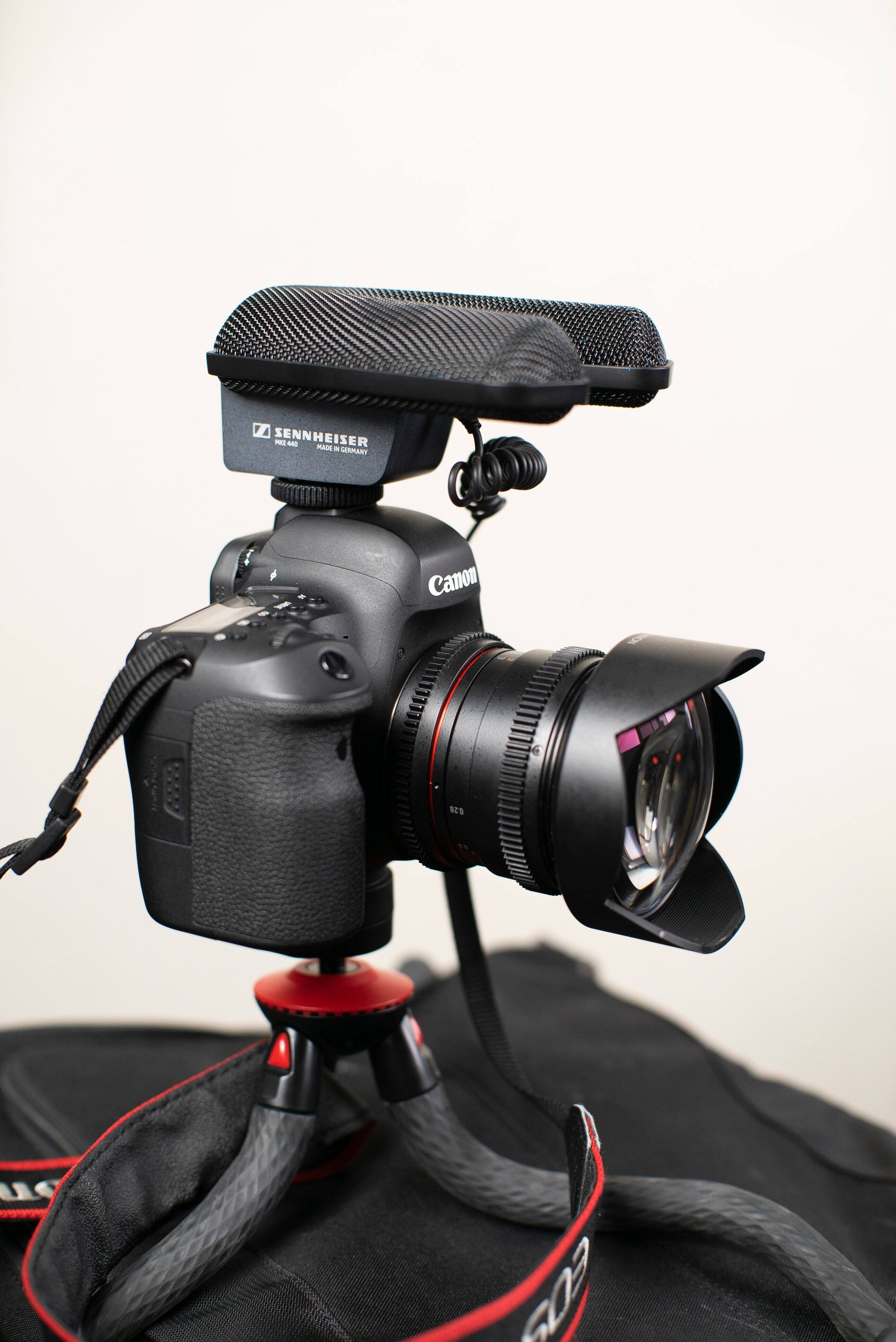 The text on the image reads "Z Sennheiser P - mAiS - TRAMEL Canon e N U SOZ." This text is likely a combination of different brands and products related to photography and audio equipment.