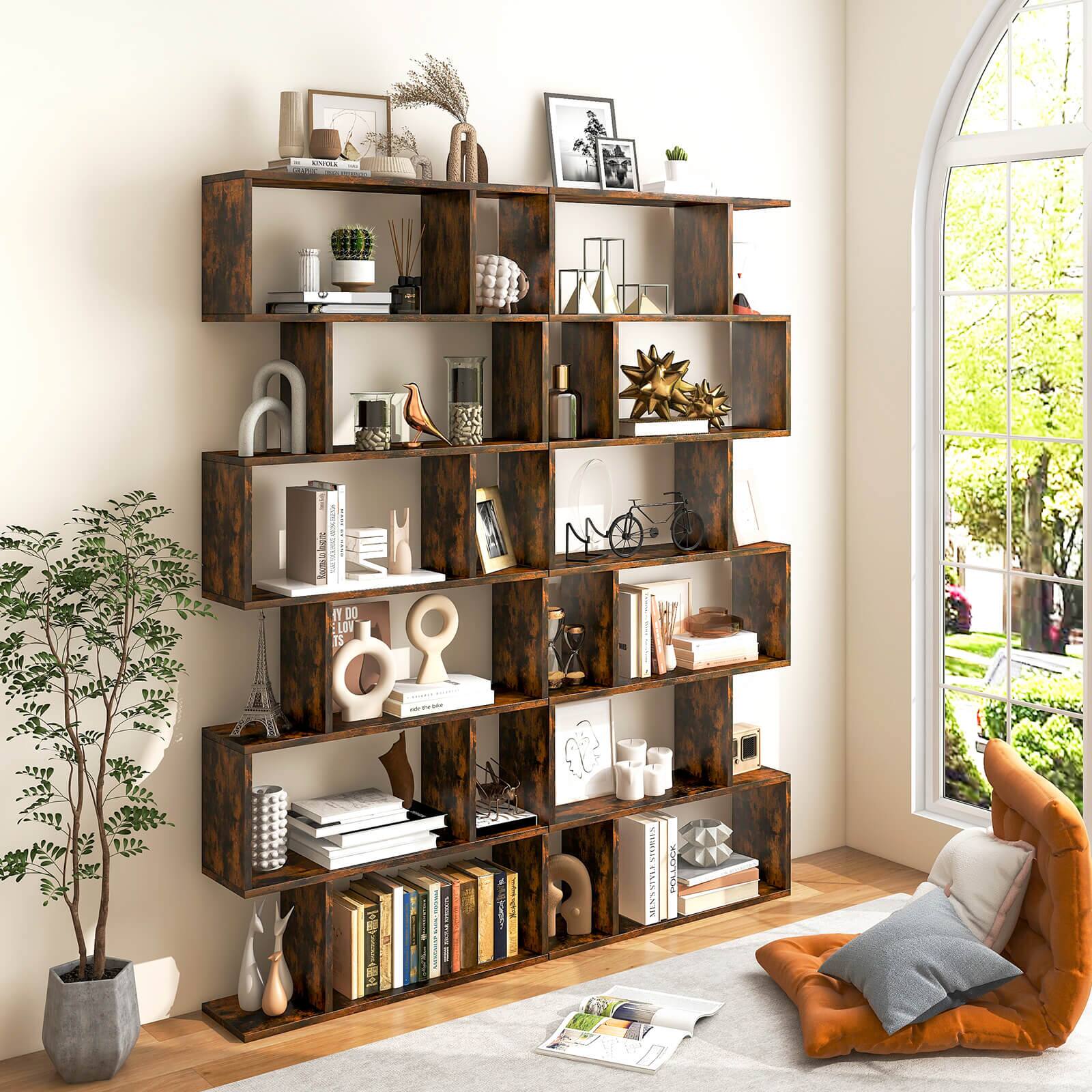 The image shows a bookshelf filled with various items, including books, vases, and a potted plant. The bookshelf is located in a living room, and there is a chair nearby. The books are arranged in different positions, with some standing upright and others lying horizontally. The vases come in various sizes and are placed at different heights on the shelf. The potted plant adds a touch of greenery to the scene, and the chair provides a comfortable seating option for the room. Overall, the image depicts a cozy and well-organized living space.
