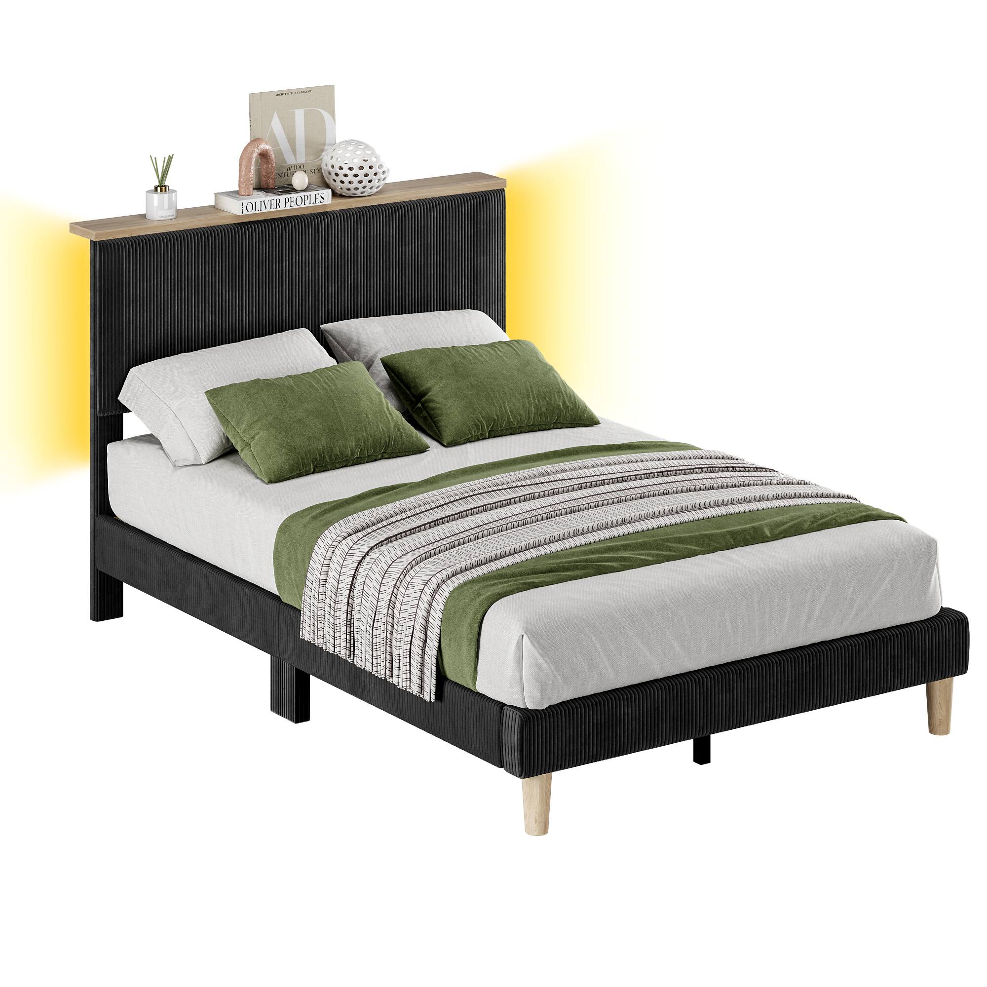 "A bed with a black headboard and a green and white striped comforter on top."