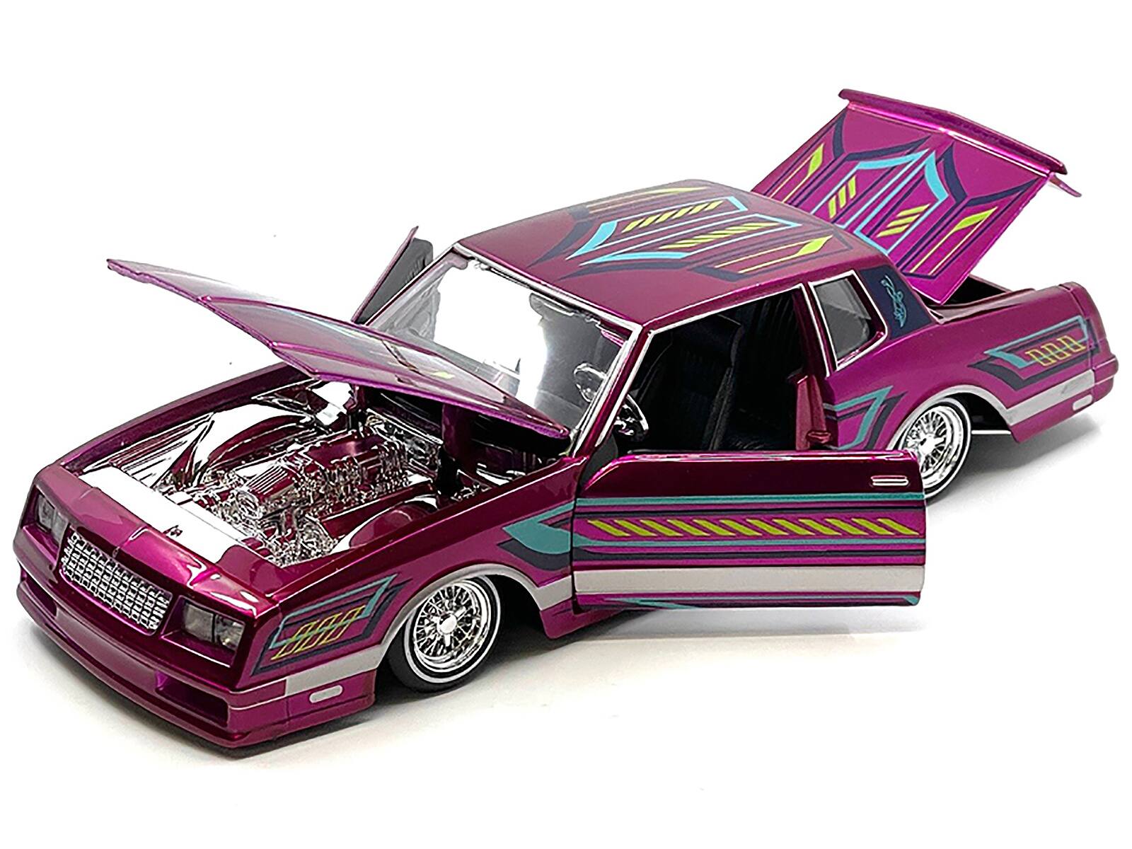 Angle. Maisto - 1986 Chevrolet Monte Carlo SS Lowrider Pink Metallic with Graphics "Lowriders" Series 1/24 Diecast Model Car by Maisto - Pink Metallic.