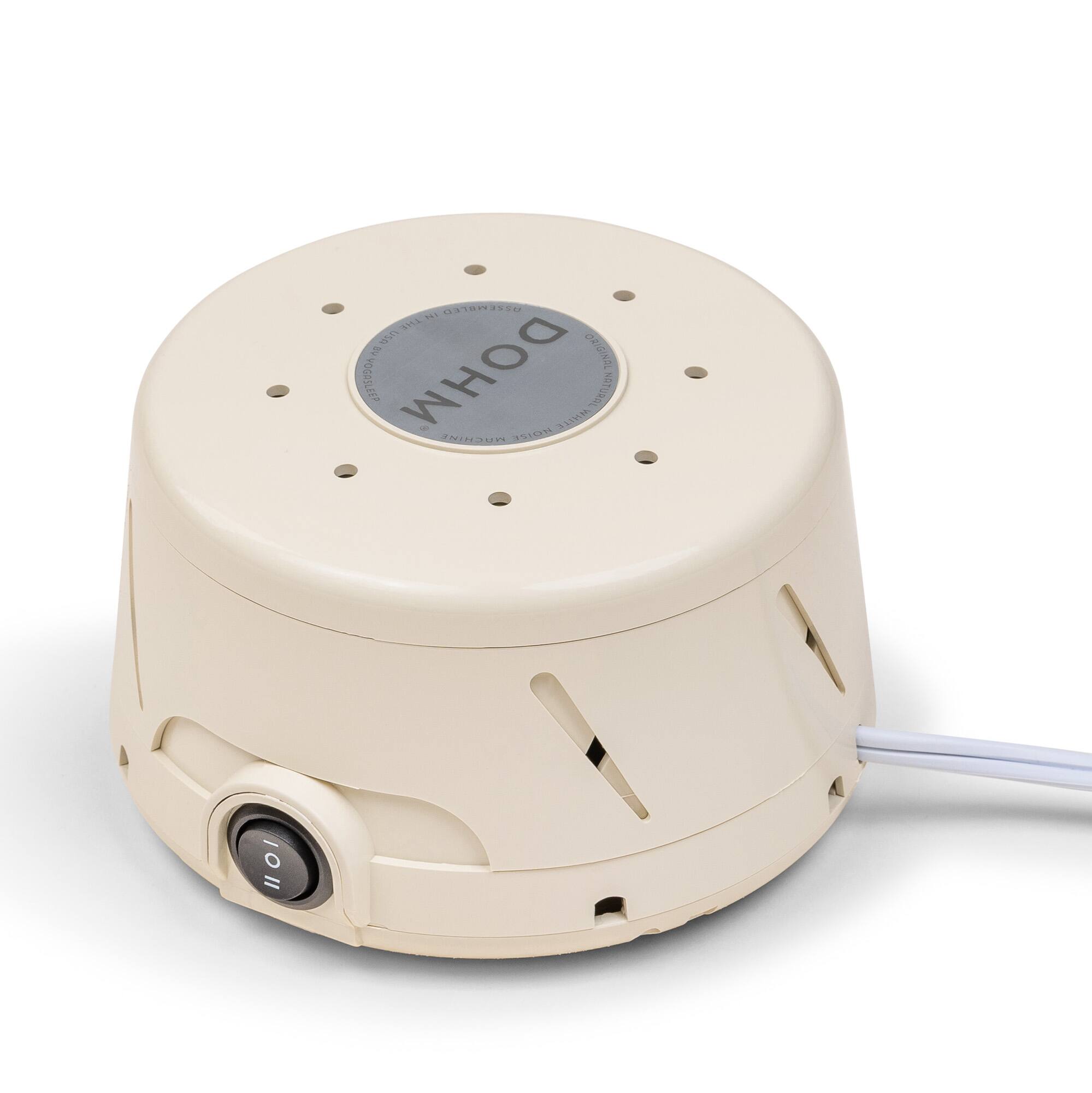 The image features a white electronic device with a grey button on top. The device is a small, portable humidifier, which is designed to provide moisture to the air. The humidifier is connected to a cord and has a plug on the back. The device is placed on a white surface, and it is likely used for personal comfort or to help with breathing issues.