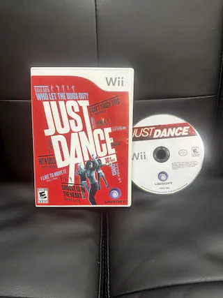 The text on the image is related to the game "Just Dance" for the Wii console. Here is the corrected and grouped text:
**Game Title:**
- Just Dance
**Songs Included:**
- Who Let the Dogs Out? - Baha Men
- I Can't Touch This - MC Hammer
- I'm Blonde - MC Hammer
- Heart of Glass - Blondie
- Pump Up the Jam - Technotronic
- Just Dance - Lady Gaga
- Hot in Here - Nelly
- Cold - Katy Perry
- I Like to Move It - Reel 2 Real
- Groove Is in the Heart - Dee-Lite
**Additional Information:**
- 30 Tracks
- Ubisoft
- ESRB Rating: E for Everyone
**Other Details:**
- Wii
- Nii
- 17580-01253-01
This text is from the cover and disc of the game "Just Dance" for the Wii console. - E (Everyone)