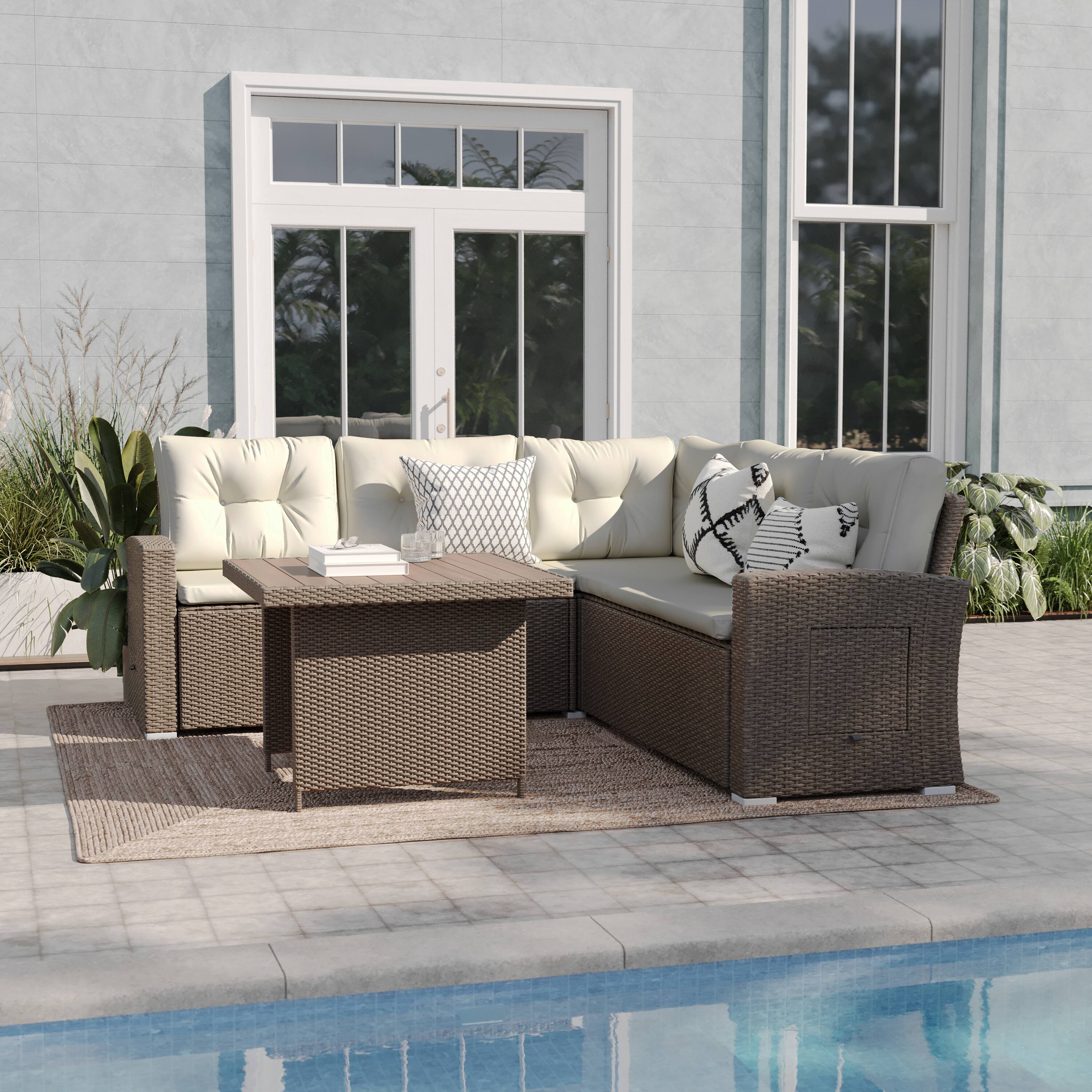 Outdoor wicker sofa and table set in a patio by a pool.