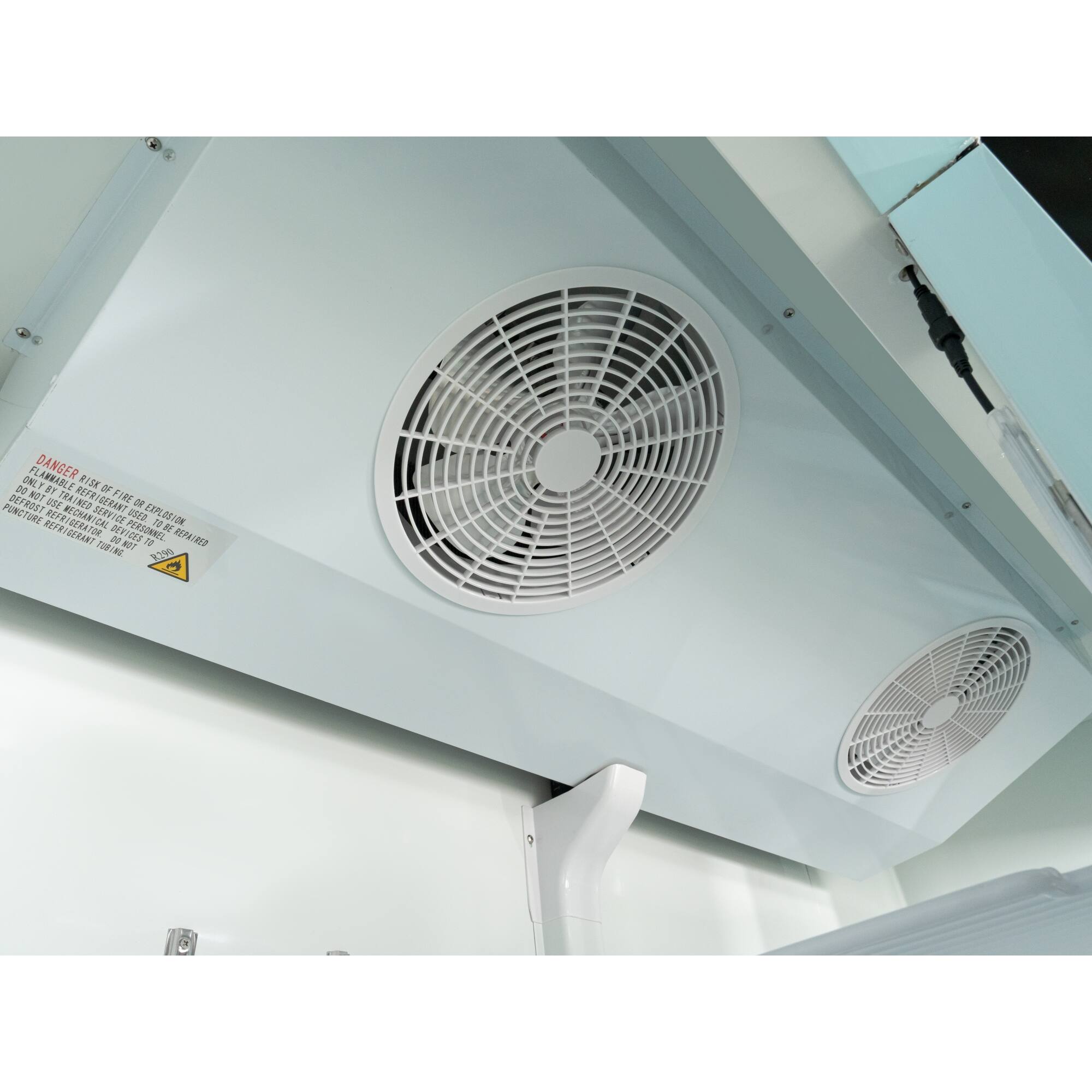 The image shows a white ventilation system with a warning sign on it. The sign reads "Flammable danger. Fire risk. Do not use electrical equipment. Refrigerator use mechanical service personnel. Used explosion-proof equipment. Explosion or fire hazard. Do not use electrical services. Refrigerator use mechanical service personnel. Used explosion-proof equipment."